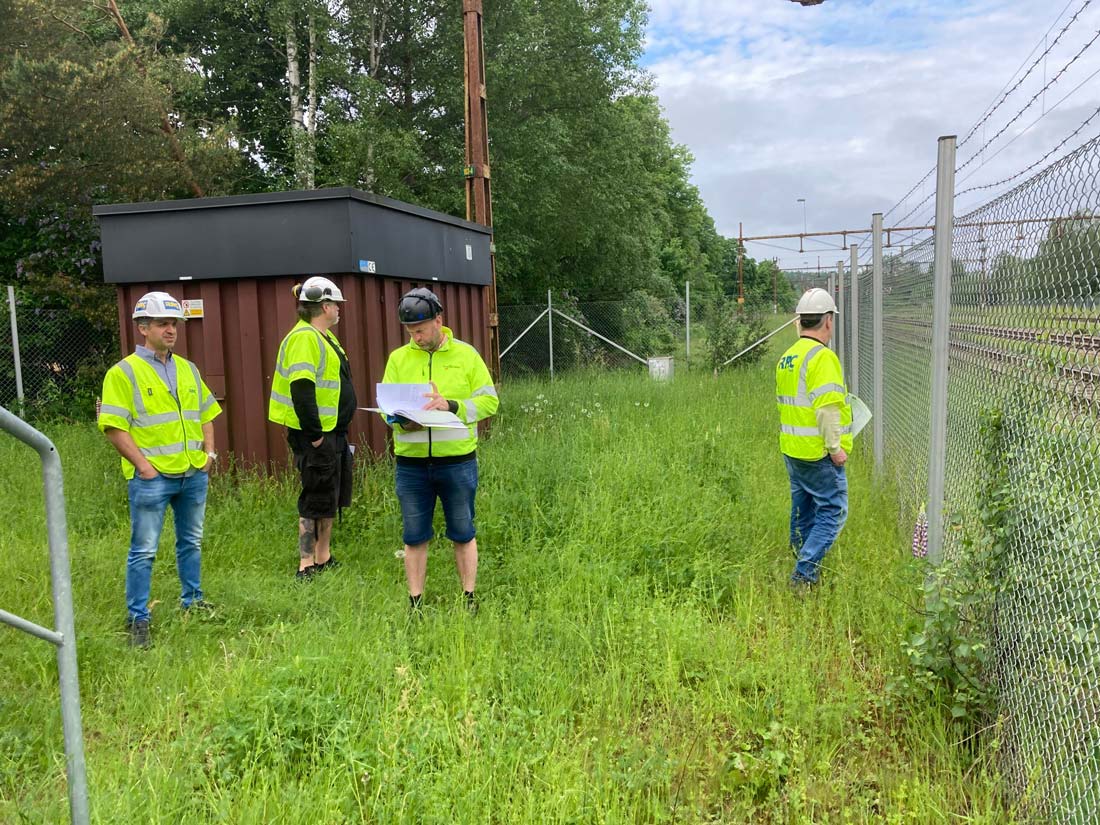 Flera personer i reflexkläder på en grön plätt.